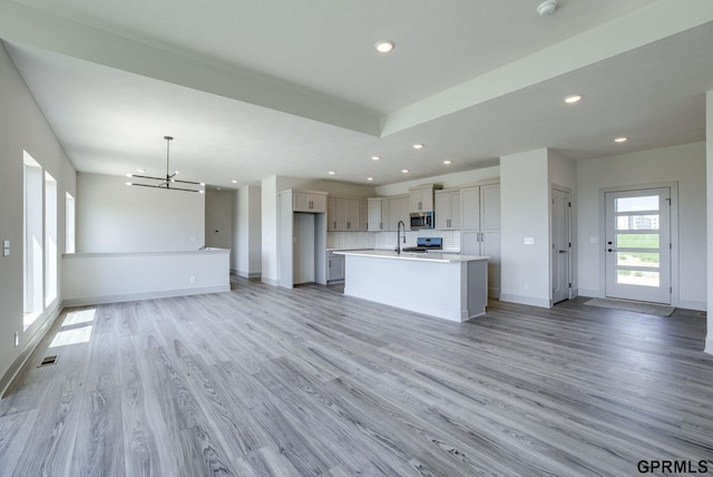 20145 S St, Omaha, NE 68135 - kitchen featuring open floor plan, a chandelier, light wood-style floors, stainless steel microwave, and recessed lighting