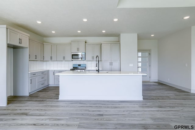 20145 S St, Omaha, NE 68135 - kitchen featuring stainless steel appliances, a sink, a center island with sink, recessed lighting, and light wood finished floors