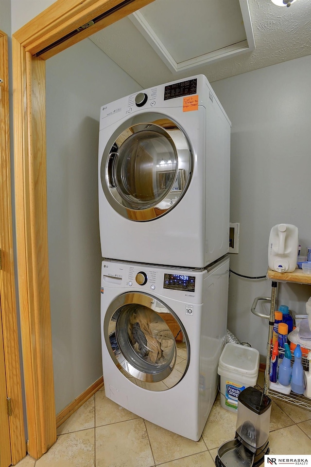 10419 N 150th St, Bennington, NE 68007 - laundry room featuring stacked washer / drying machine, light tile patterned floors, and baseboards