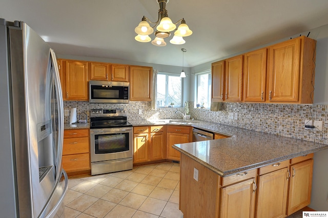 10419 N 150th St, Bennington, NE 68007 - kitchen with appliances with stainless steel finishes, a peninsula, decorative backsplash, and light tile patterned floors