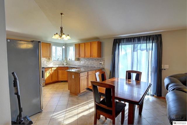 10419 N 150th St, Bennington, NE 68007 - kitchen with freestanding refrigerator, a chandelier, decorative backsplash, light tile patterned floors, and pendant lighting