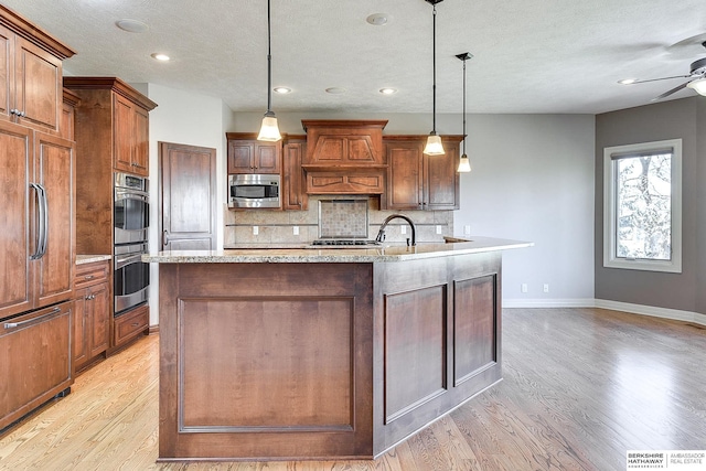 19252 Shirley St, Omaha, NE 68130 - kitchen featuring built in appliances, a ceiling fan, light wood-style flooring, decorative backsplash, and recessed lighting