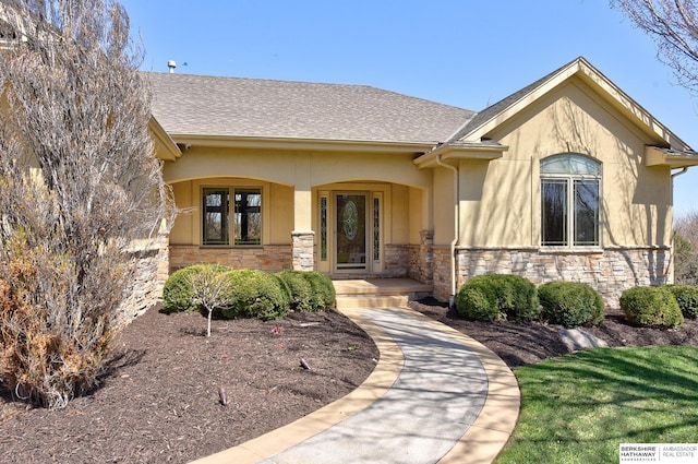 19252 Shirley St, Omaha, NE 68130 - property entrance featuring stone siding, stucco siding, a porch, and a shingled roof