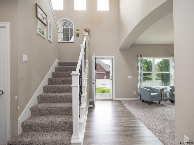 15218 Vane St, Bennington, NE 68007 - entryway featuring arched walkways, stairway, wood finished floors, and a towering ceiling