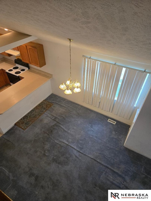 4555 Meredith Ave, Omaha, NE 68104 - unfurnished dining area with a textured ceiling, carpet floors, and a chandelier