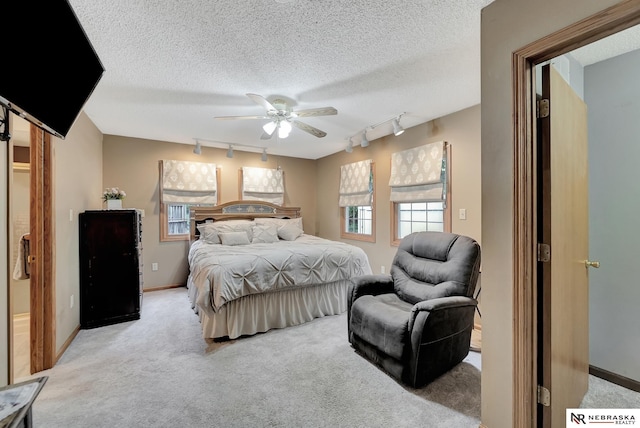 7105 W Davey Rd, Raymond, NE 68428 - bedroom with track lighting, light carpet, baseboards, a textured ceiling, and ceiling fan
