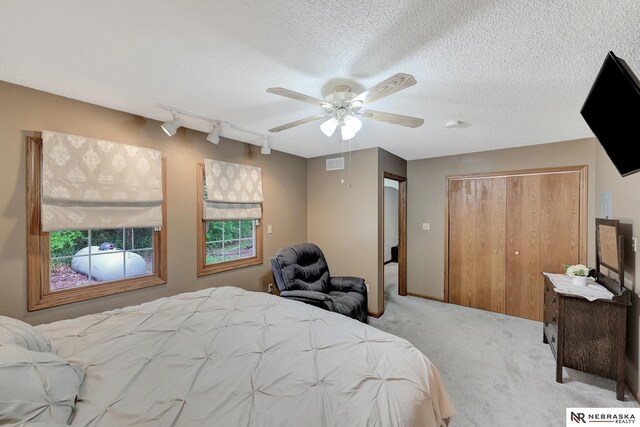 7105 W Davey Rd, Raymond, NE 68428 - carpeted bedroom with track lighting, a closet, ceiling fan, and a textured ceiling