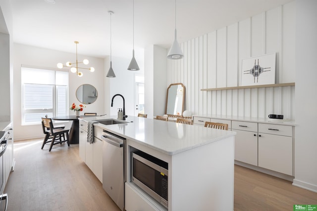 5320 Elmwood Plz, Omaha, NE 68106 - kitchen with stainless steel appliances, light wood-style flooring, white cabinetry, a sink, and a chandelier