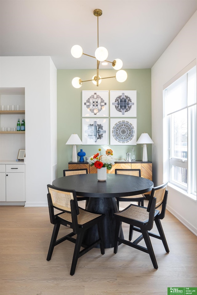 5320 Elmwood Plz, Omaha, NE 68106 - dining room featuring light wood-style floors, baseboards, and a chandelier