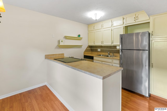 12726 Gail Plz Unit 107, Omaha, NE 68137 - kitchen with stainless steel appliances, a sink, a peninsula, light wood-style flooring, and backsplash