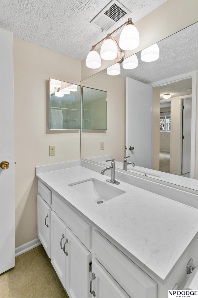 12726 Gail Plz Unit 107, Omaha, NE 68137 - bathroom featuring a textured ceiling, vanity, baseboards, and tile patterned flooring