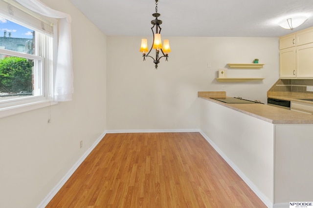 12726 Gail Plz Unit 107, Omaha, NE 68137 - unfurnished dining area with light wood-type flooring, baseboards, and a chandelier
