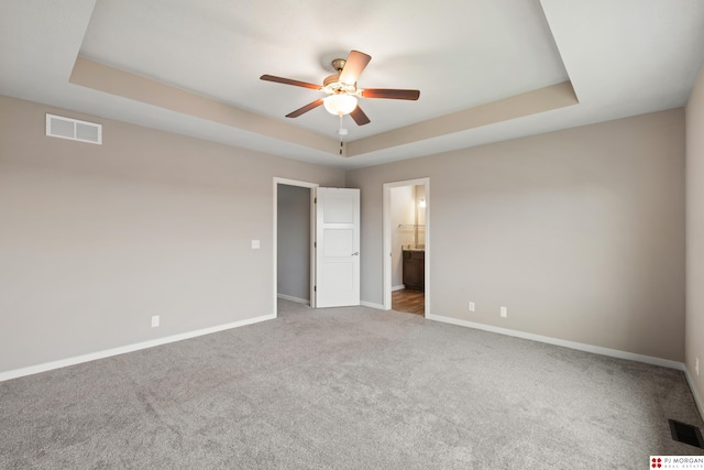 7775 N 149th St, Bennington, NE 68007 - unfurnished bedroom featuring baseboards, carpet flooring, a raised ceiling, connected bathroom, and a ceiling fan