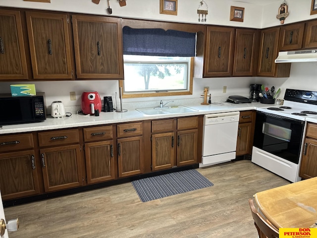 802 Main St, Bancroft, NE 68004 - kitchen with white dishwasher, electric stove, under cabinet range hood, black microwave, and a sink