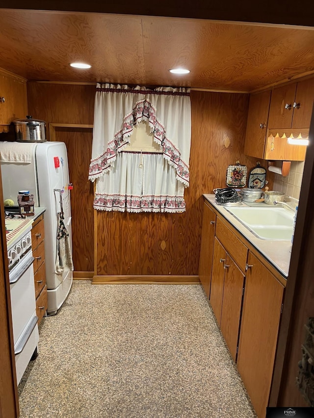 2031 N 49th St, Omaha, NE 68104 - kitchen featuring brown cabinetry, white appliances, light countertops, and wooden walls