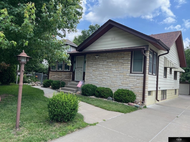 2031 N 49th St, Omaha, NE 68104 - view of front of home with stone siding, a front lawn, and a shingled roof