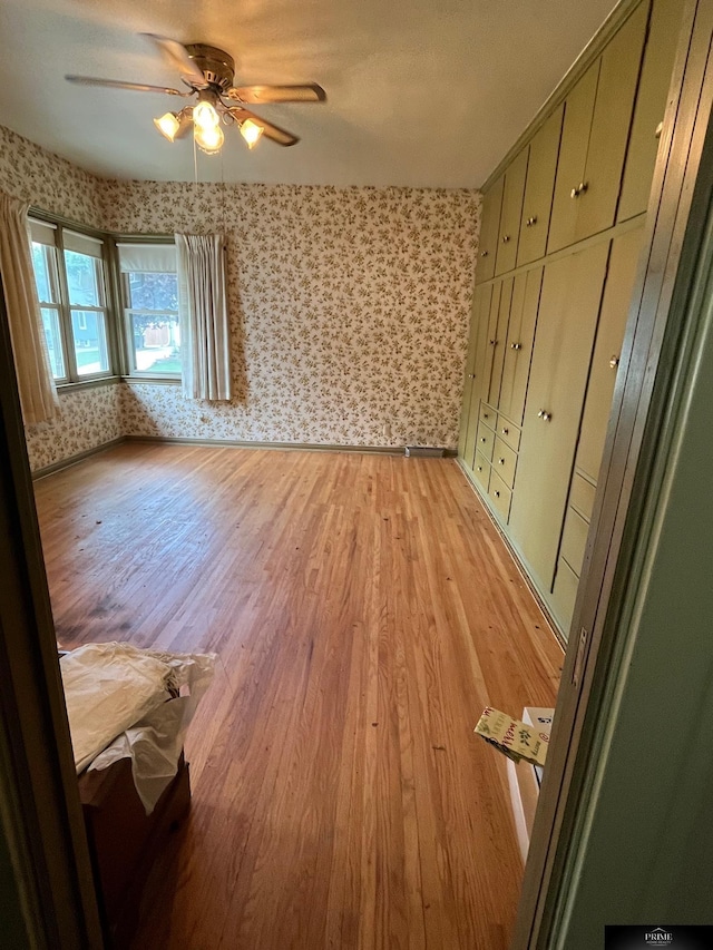 2031 N 49th St, Omaha, NE 68104 - unfurnished bedroom featuring wallpapered walls, light wood-type flooring, and ceiling fan