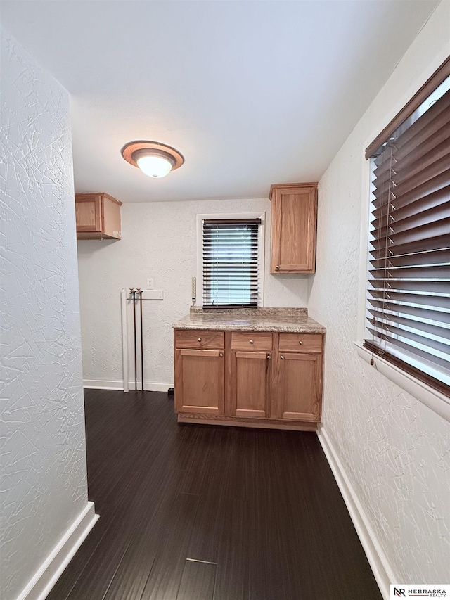3836 Drexel St, Omaha, NE 68107 - kitchen featuring a textured wall, baseboards, and dark wood-style floors