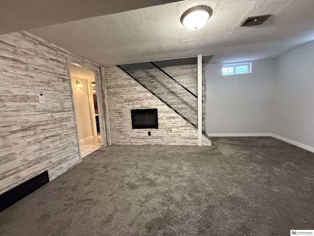 3836 Drexel St, Omaha, NE 68107 - below grade area with wooden walls, carpet floors, a textured ceiling, a large fireplace, and baseboards