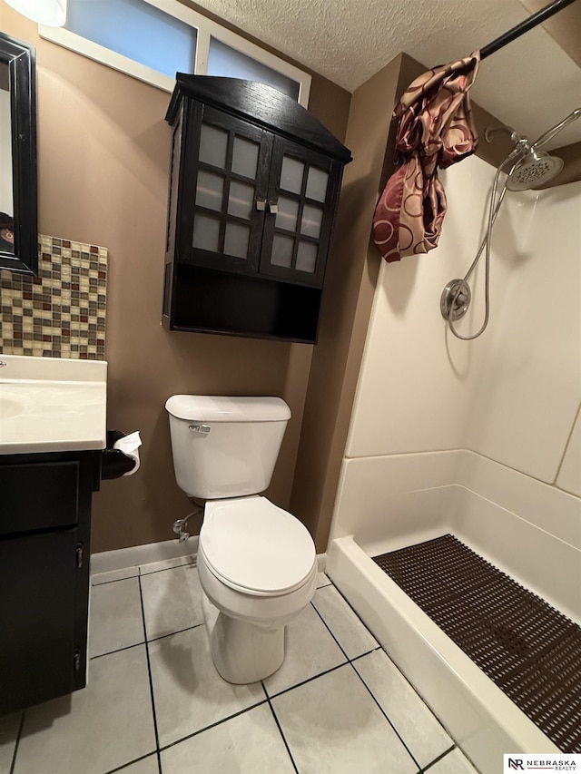 3836 Drexel St, Omaha, NE 68107 - full bathroom with a stall shower, toilet, vanity, tile patterned flooring, and a textured ceiling