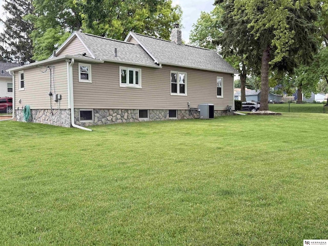 3836 Drexel St, Omaha, NE 68107 - view of side of property featuring a yard, a chimney, roof with shingles, and central AC