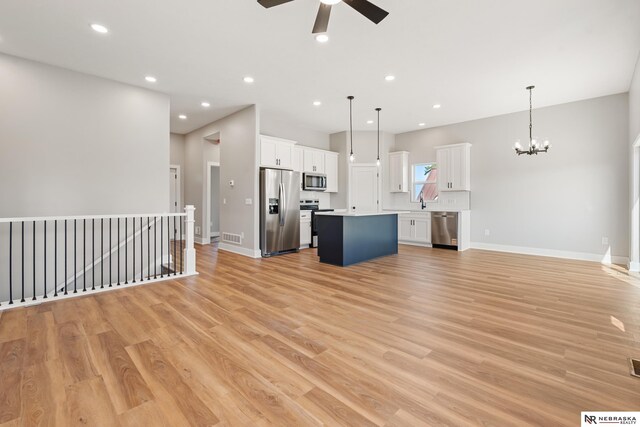 1713 M St, Tekamah, NE 68061 - unfurnished living room featuring ceiling fan, a chandelier, light wood-type flooring, baseboards, and recessed lighting