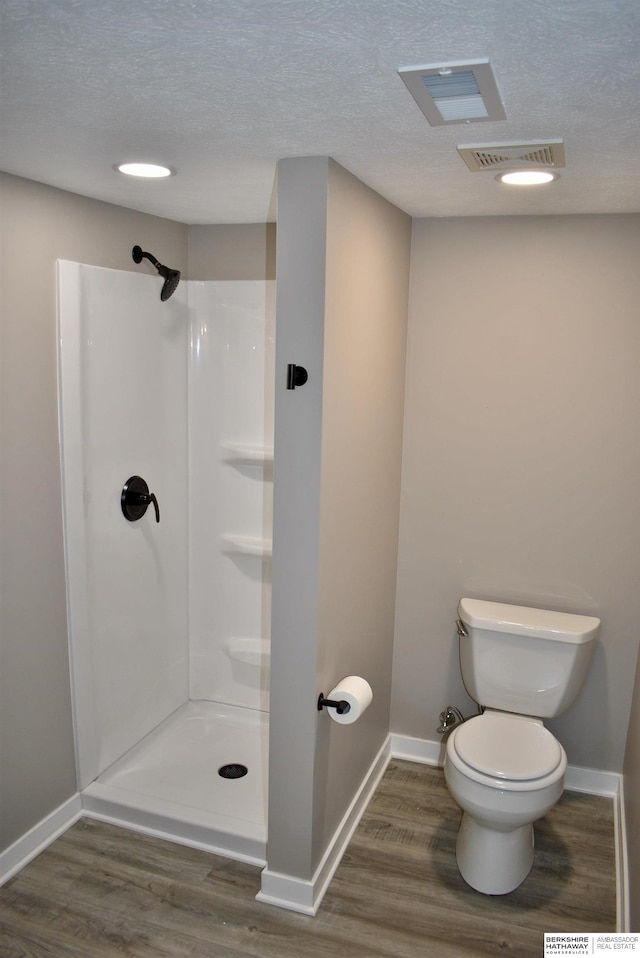 116 8th St, Scribner, NE 68057 - bathroom featuring toilet, wood finished floors, a shower, baseboards, and a textured ceiling