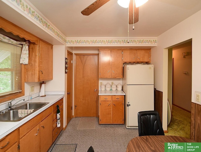 1609 N 71st St, Lincoln, NE 68505 - kitchen with freestanding refrigerator, a sink, light countertops, and brown cabinets