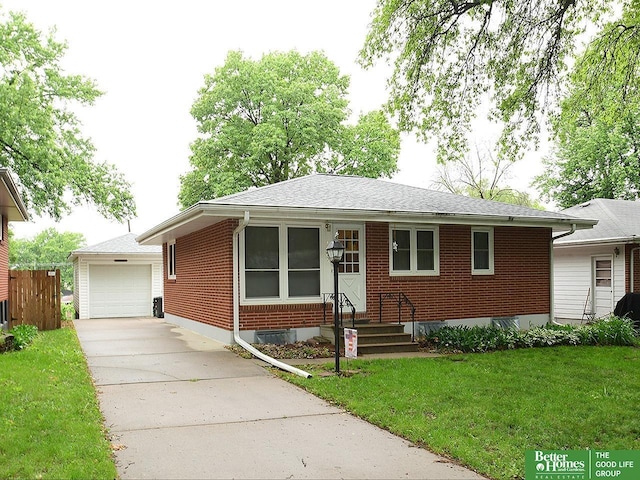1609 N 71st St, Lincoln, NE 68505 - ranch-style house featuring brick siding, driveway, a front yard, a detached garage, and a shingled roof
