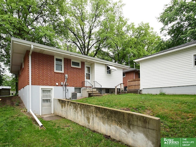 1609 N 71st St, Lincoln, NE 68505 - back of property featuring a yard, central AC, and brick siding