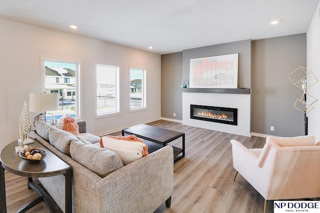 17010 Daniel St, Bennington, NE 68007 - living area featuring a glass covered fireplace, light wood-style floors, recessed lighting, and baseboards