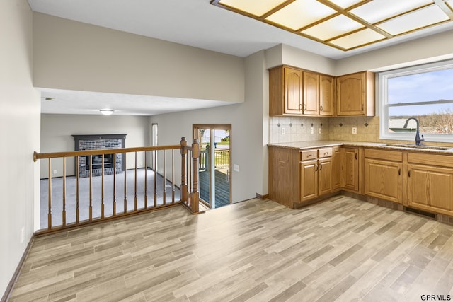 10103 S 11th St, Bellevue, NE 68123 - kitchen featuring a sink, light wood-style flooring, brown cabinets, and decorative backsplash