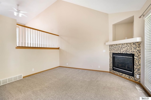 3015 N 144th Ter, Omaha, NE 68116 - unfurnished living room featuring carpet, ceiling fan, a tile fireplace, baseboards, and lofted ceiling