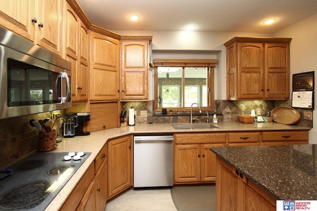 2600 Evergreen Cir, Beatrice, NE 68310 - kitchen featuring appliances with stainless steel finishes, a sink, decorative backsplash, dark stone countertops, and recessed lighting