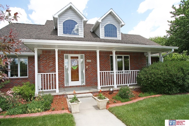 2600 Evergreen Cir, Beatrice, NE 68310 - view of front of property featuring a porch, brick siding, and roof with shingles