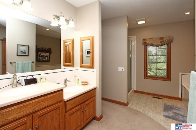 2600 Evergreen Cir, Beatrice, NE 68310 - full bath featuring double vanity, a stall shower, baseboards, decorative backsplash, and recessed lighting
