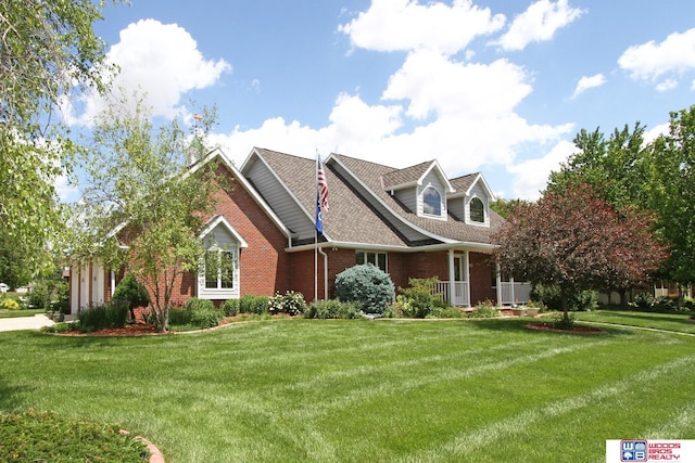 2600 Evergreen Cir, Beatrice, NE 68310 - cape cod-style house with brick siding, a front lawn, an attached garage, a porch, and a shingled roof
