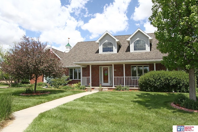 2600 Evergreen Cir, Beatrice, NE 68310 - cape cod house featuring brick siding, a front lawn, covered porch, and a shingled roof