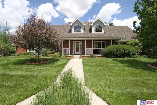 2600 Evergreen Cir, Beatrice, NE 68310 - new england style home with brick siding, covered porch, and a front yard