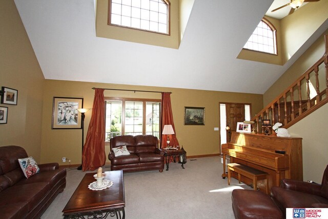 2600 Evergreen Cir, Beatrice, NE 68310 - carpeted living area with high vaulted ceiling, baseboards, stairway, and ceiling fan