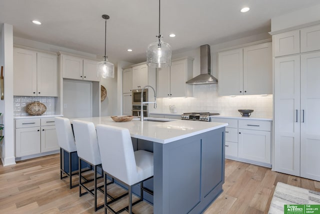 3639 S 218th Ave, Elkhorn, NE 68022 - kitchen featuring wall chimney exhaust hood, backsplash, a sink, light wood-style floors, and a center island with sink