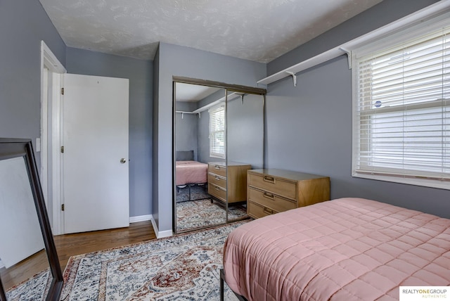 12180 Pedersen Dr, Omaha, NE 68144 - bedroom featuring wood finished floors, a closet, and baseboards