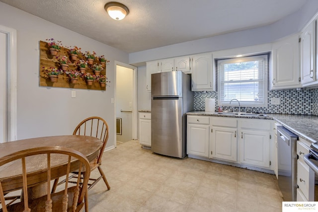 12180 Pedersen Dr, Omaha, NE 68144 - kitchen featuring stainless steel appliances, a sink, backsplash, white cabinets, and a textured ceiling