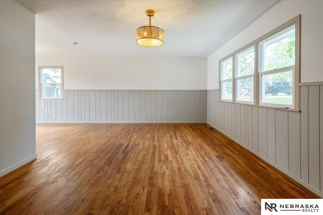 8261 Stephanie Ln, Bellevue, NE 68147 - unfurnished room with wood finished floors, wainscoting, and plenty of natural light