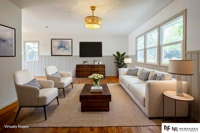 8261 Stephanie Ln, Bellevue, NE 68147 - living area featuring healthy amount of natural light, a wainscoted wall, and wood finished floors