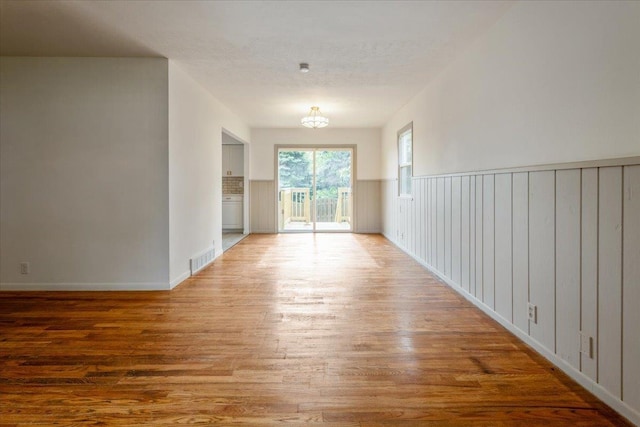 8261 Stephanie Ln, Bellevue, NE 68147 - empty room with wood finished floors, baseboards, and a chandelier