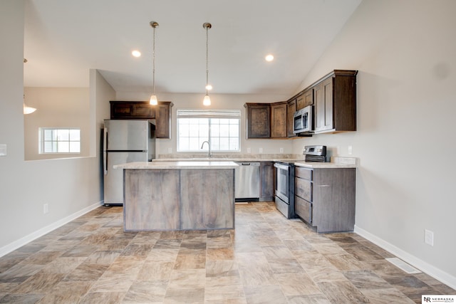 7707 N 88th St, Omaha, NE 68122 - kitchen with appliances with stainless steel finishes, a center island, dark brown cabinetry, light countertops, and a sink
