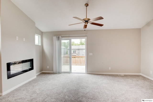 7707 N 88th St, Omaha, NE 68122 - unfurnished living room with carpet, a glass covered fireplace, ceiling fan, baseboards, and vaulted ceiling