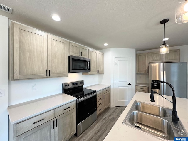 929 S Columbia Ave, Seward, NE 68434 - kitchen with appliances with stainless steel finishes, a sink, wood finished floors, light countertops, and decorative light fixtures
