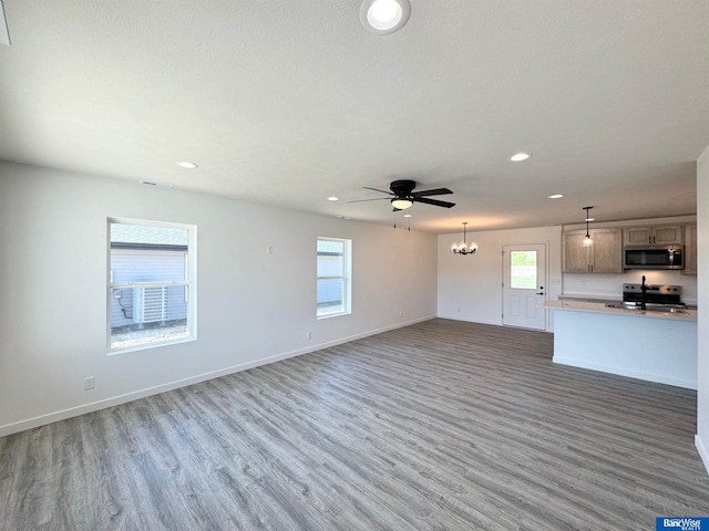 929 S Columbia Ave, Seward, NE 68434 - unfurnished living room with recessed lighting, wood finished floors, a chandelier, baseboards, and a ceiling fan